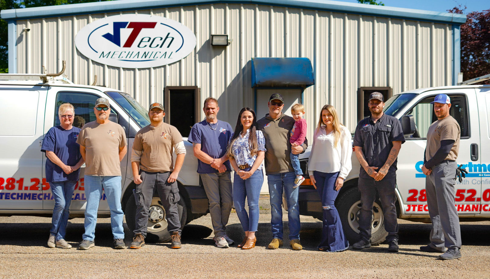 Group of staff memebers from JTech Mechanical standing in from of their metal shop building